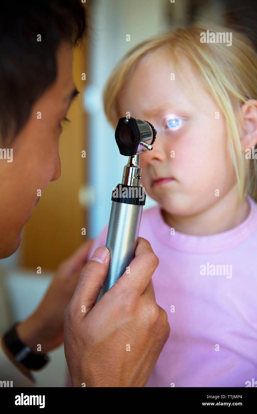 Doctor examining girl's eye Stock Photo
