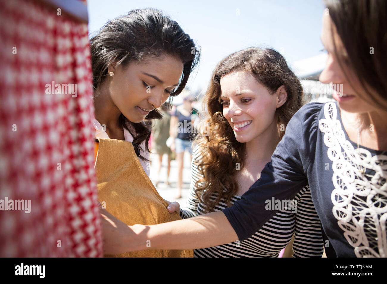 Women shopping cloths at market stall Stock Photo