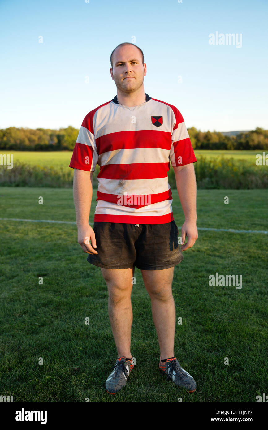 Full length portrait of rugby player standing on grassy field Stock Photo