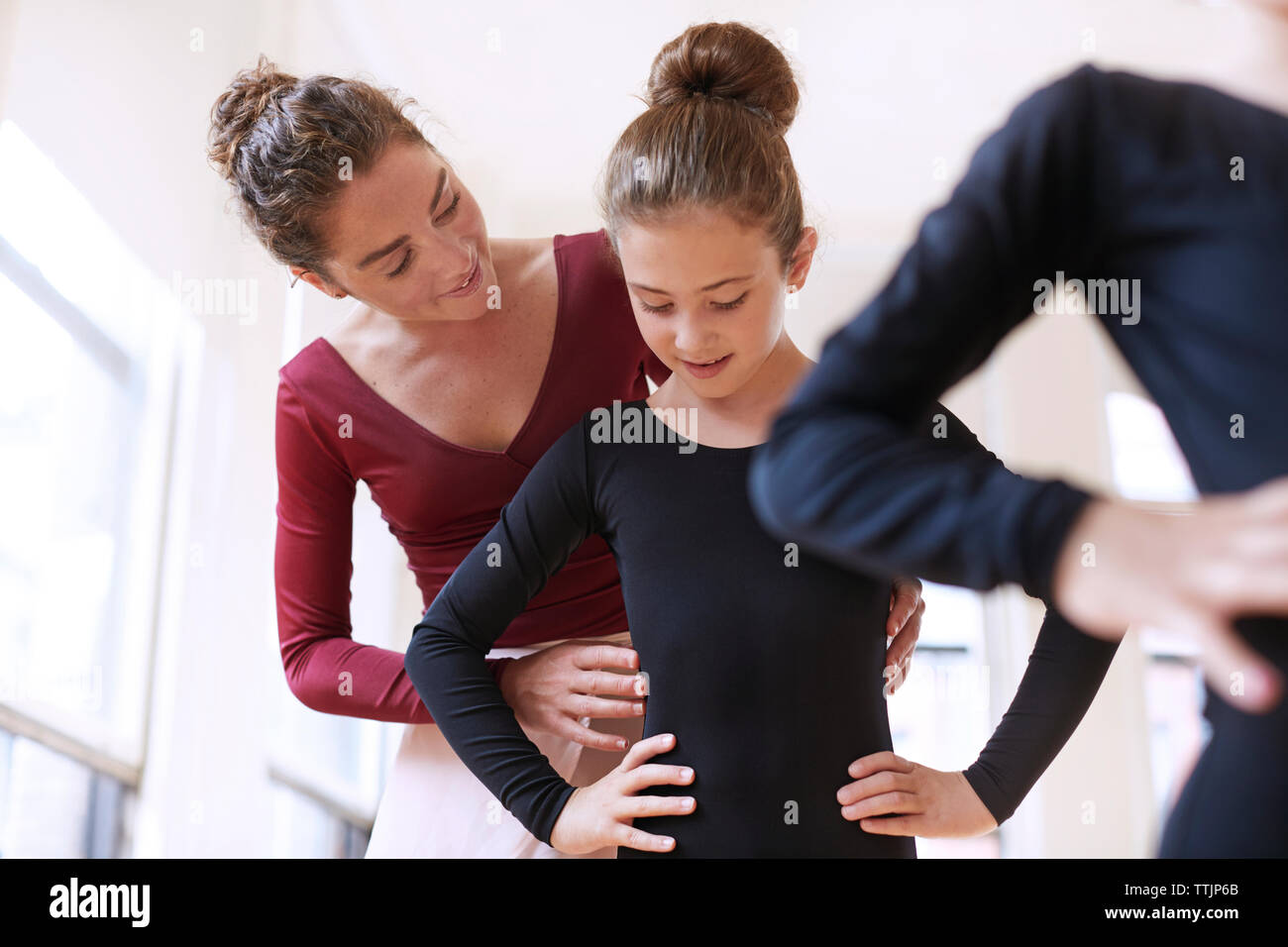 Ballet teacher assisting ballerina in studio Stock Photo