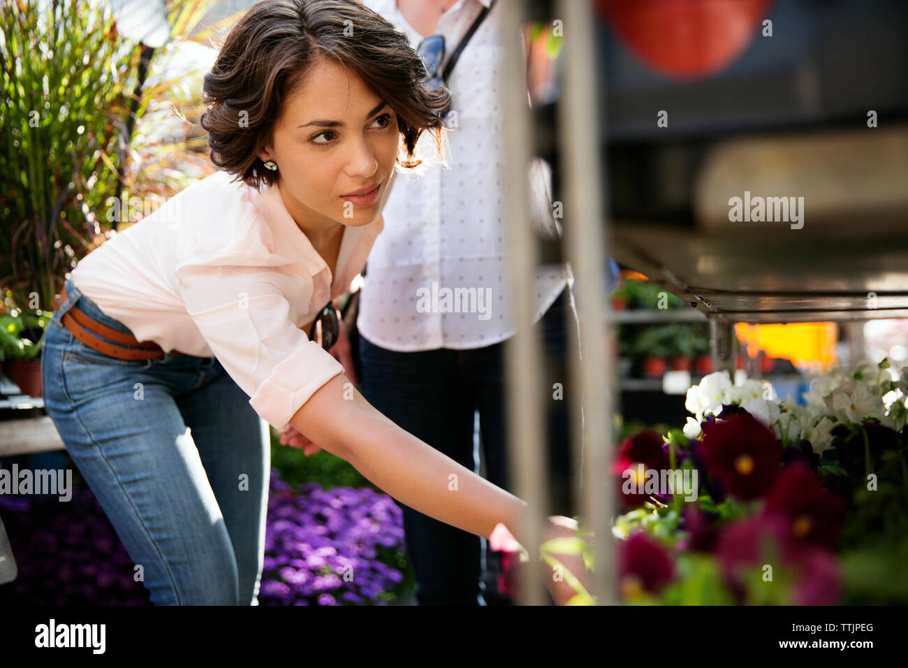 Young woman choosing flowers at shop Stock Photo