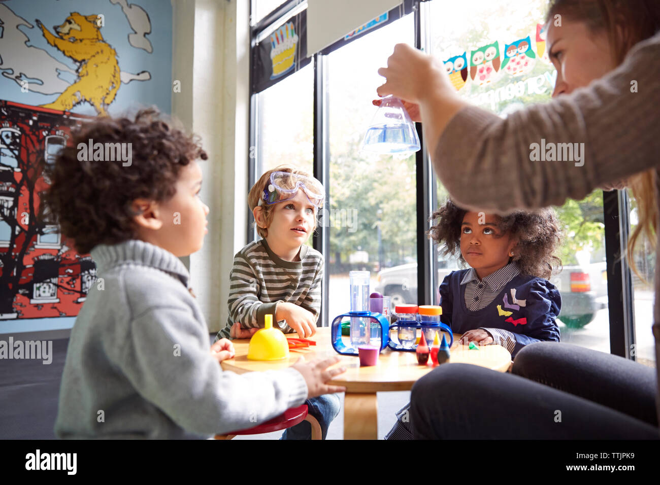 Teacher showing science experiment to children at preschool Stock Photo