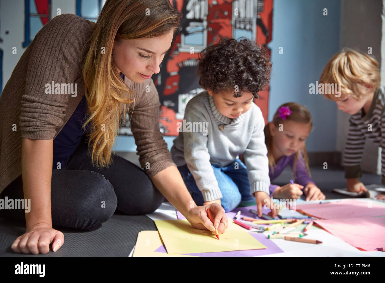 Teacher drawing on papers with students at preschool Stock Photo Alamy