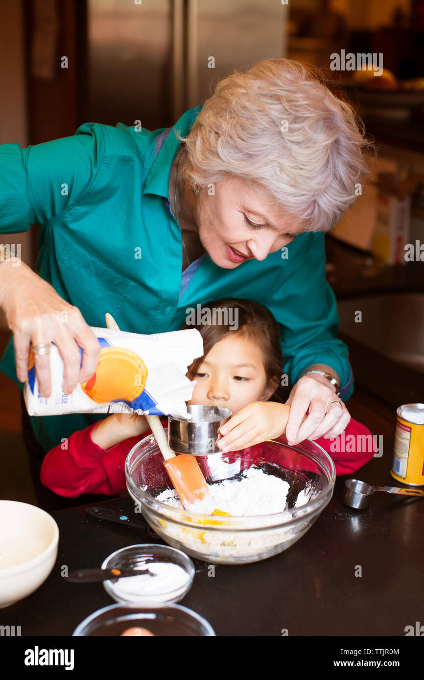 Senior woman with granddaughter preparing food at home Stock Photo