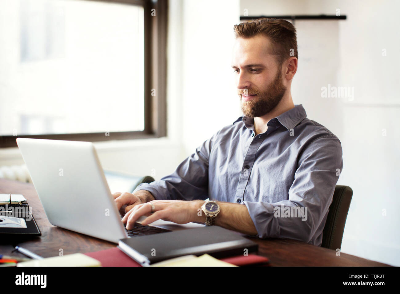 Businessman working on laptop computer in office Stock Photo - Alamy