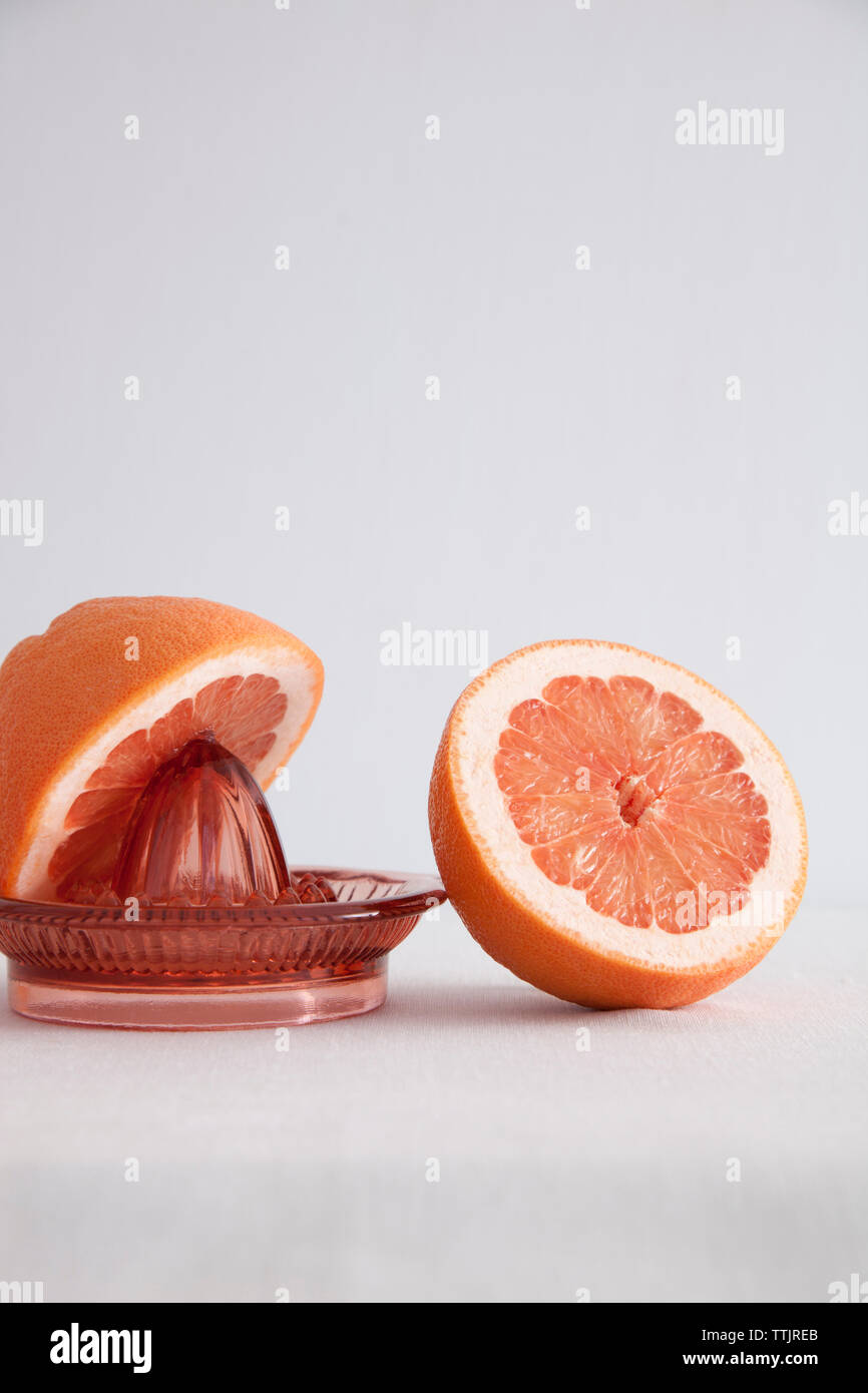 Grapefruit with juicer against white background Stock Photo Alamy
