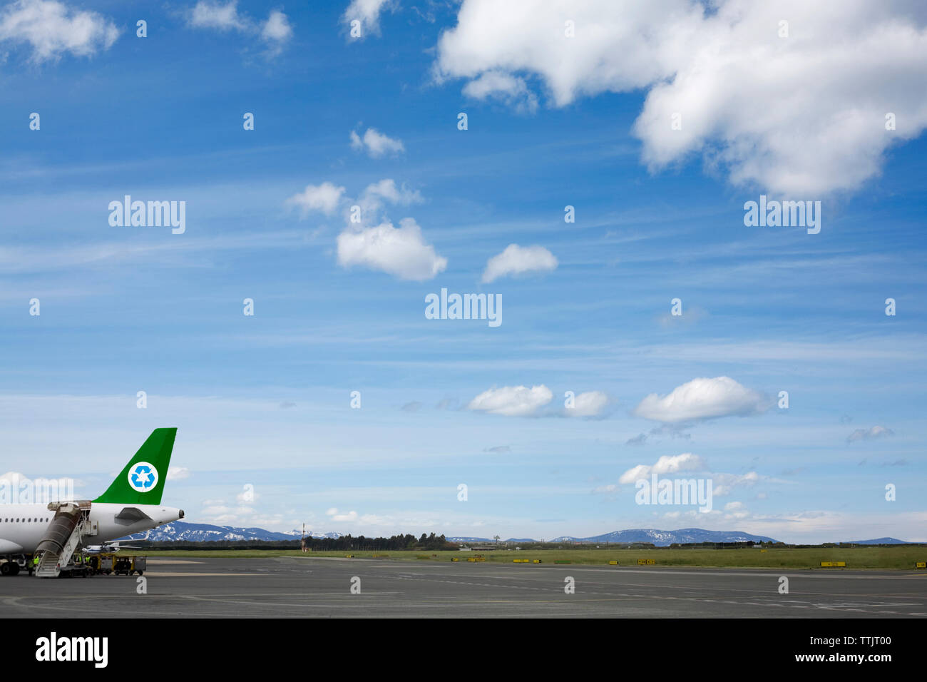 Cropped image of airplane on runway against sky Stock Photo