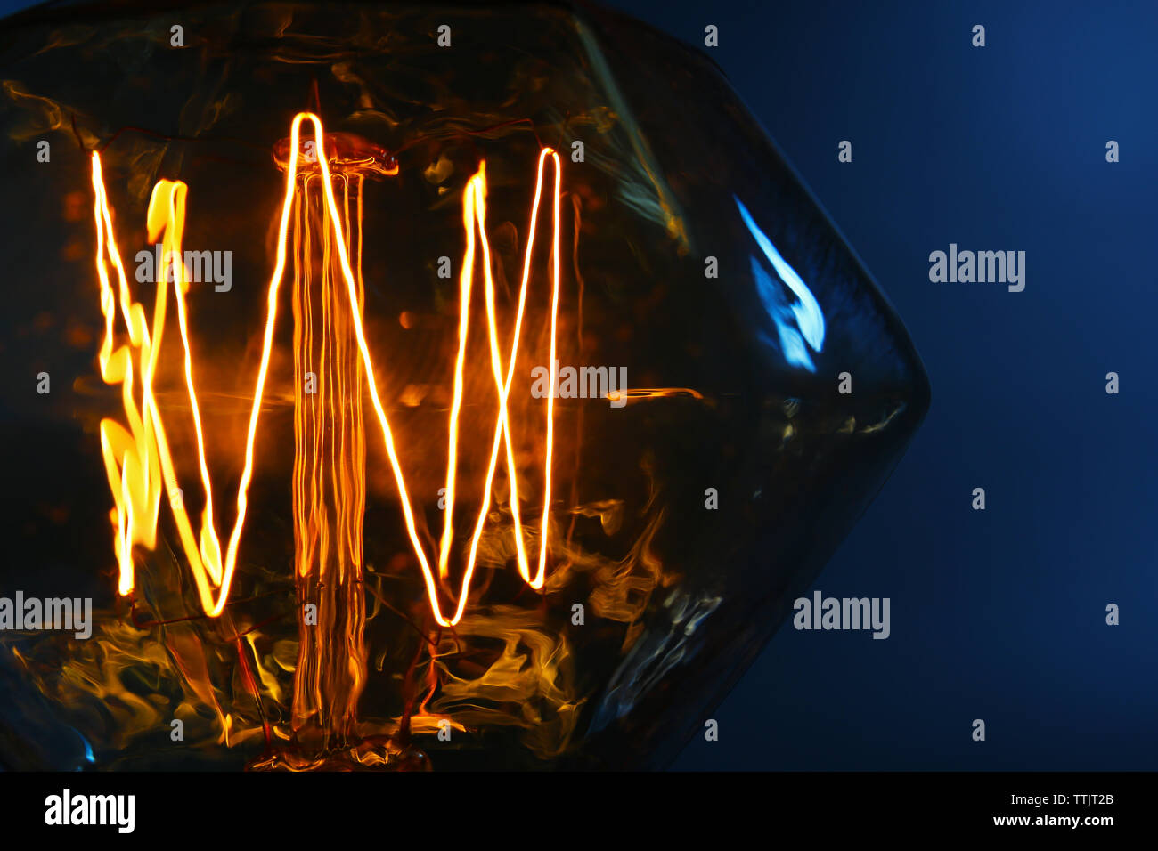 Illuminated light bulb on dark blue background Stock Photo - Alamy