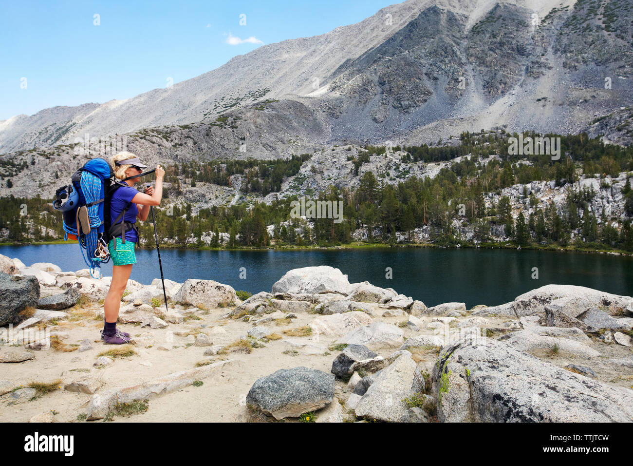 Hiker standing at mountain lake hi-res stock photography and images - Alamy