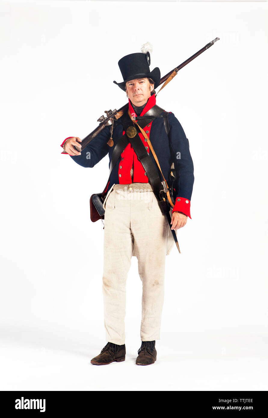 Portrait of man in army soldier costume standing against white background Stock Photo