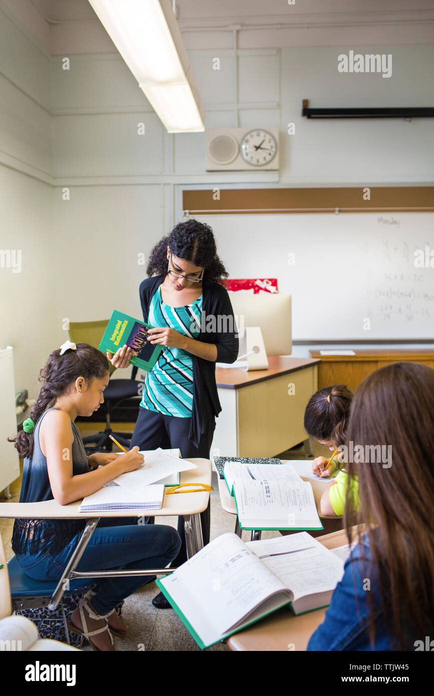 Teacher looking at student while teaching in classroom Stock Photo