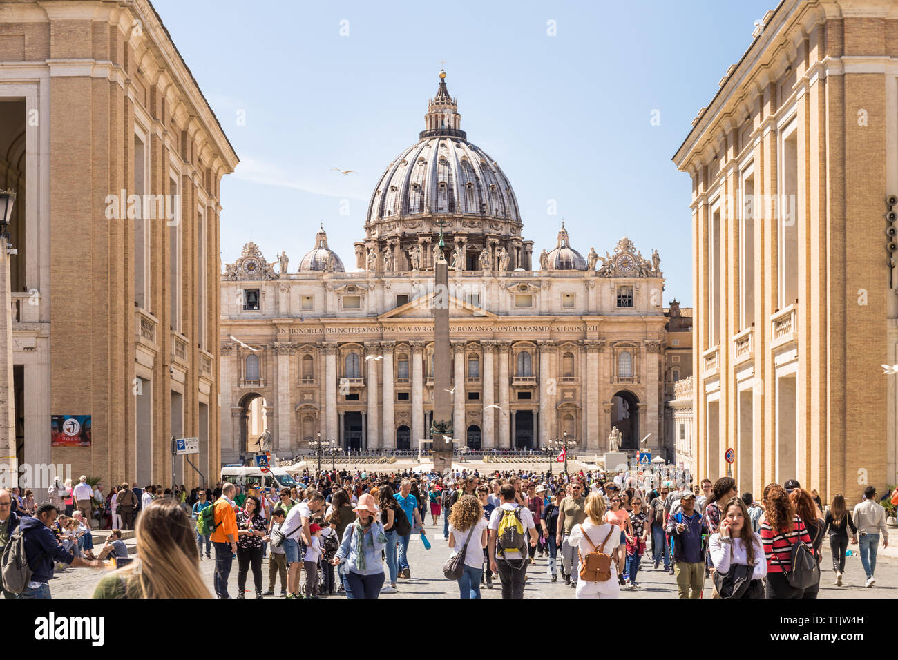 ROME, ITALY - APRIL 27, 2019: People walking along the famous via della Conciliazione with the Saint Peter Basilica in the distance. Stock Photo