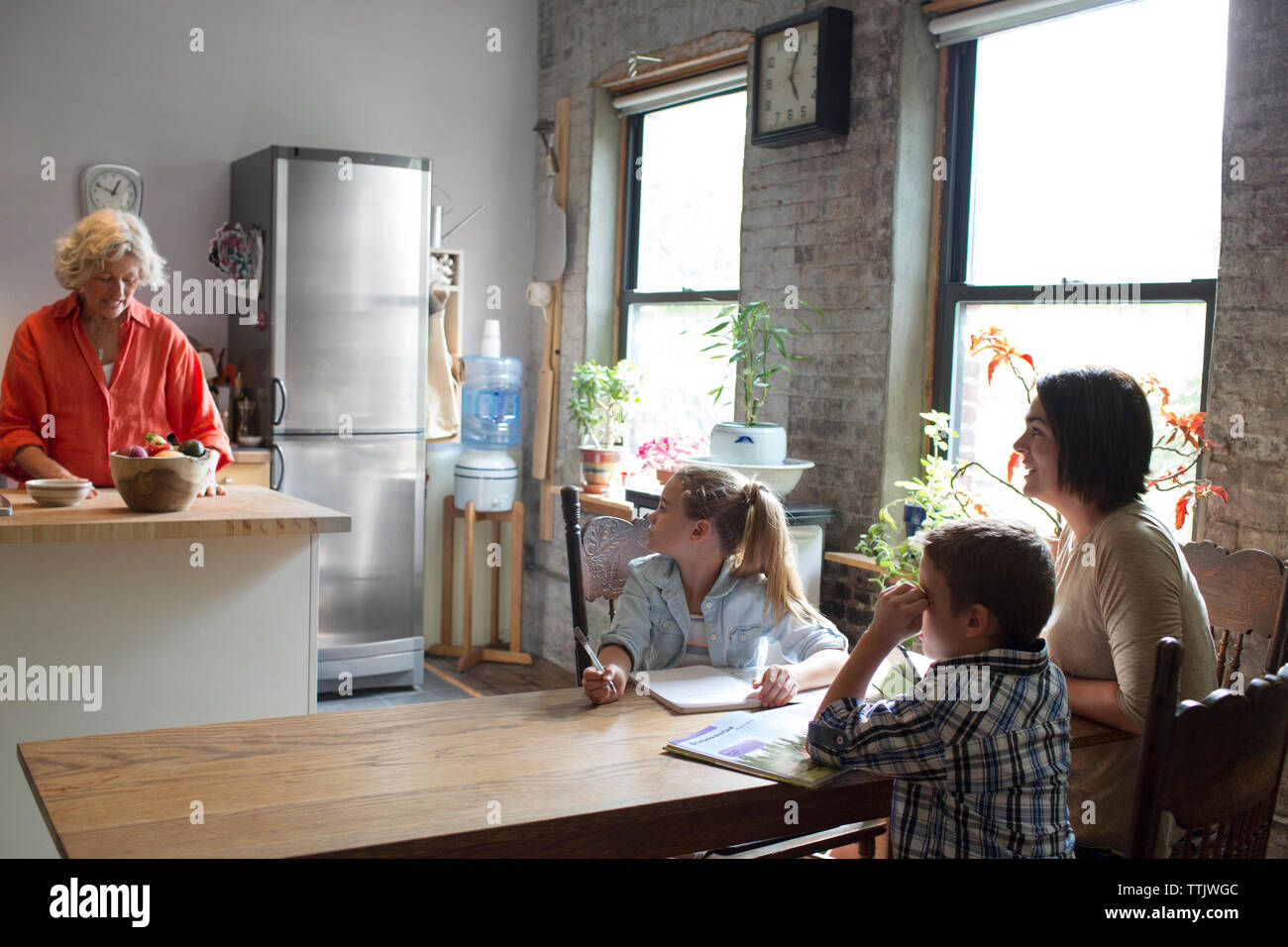 Woman talking to children studying at home Stock Photo