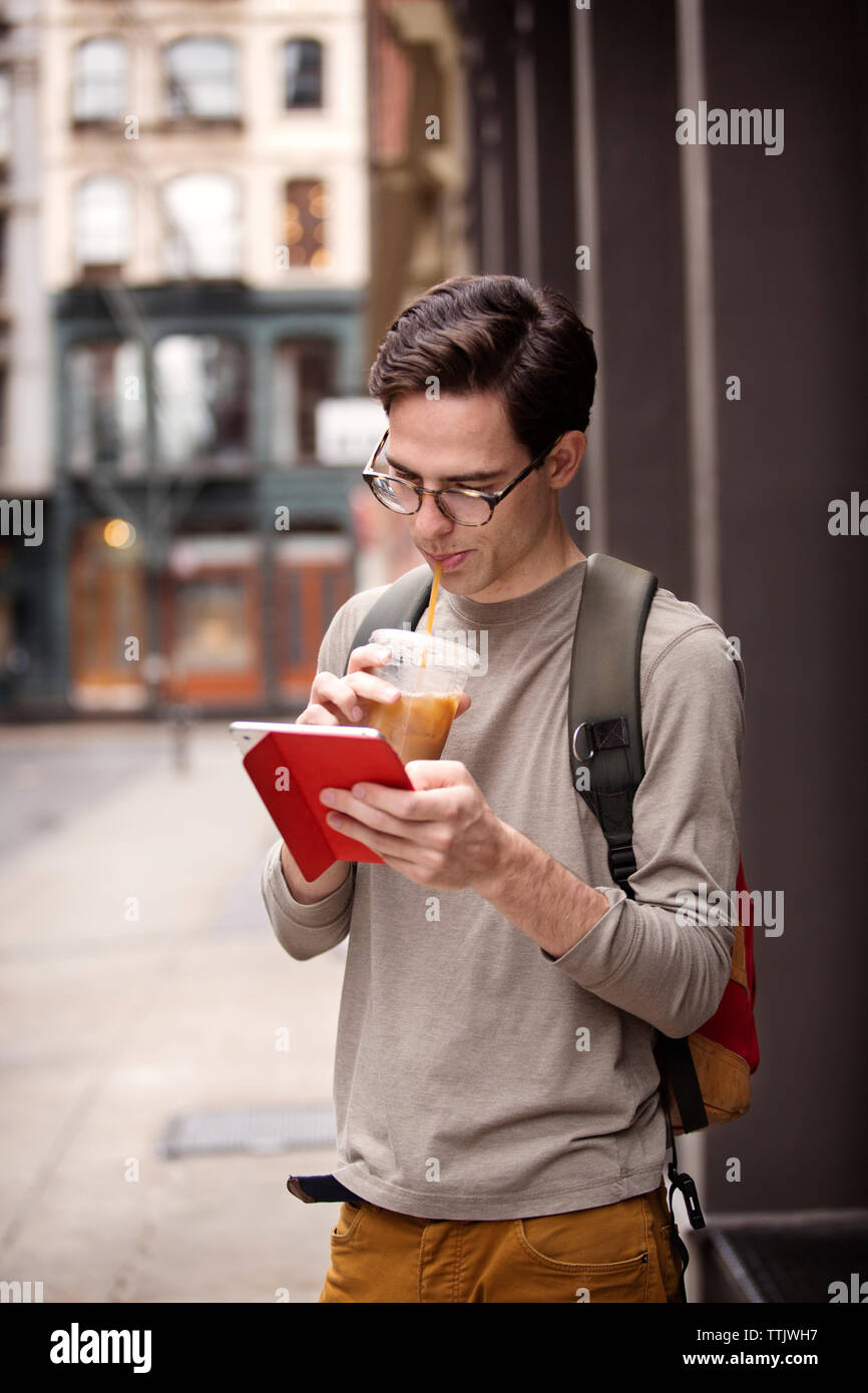 Man drinking juice while using tablet computer Stock Photo