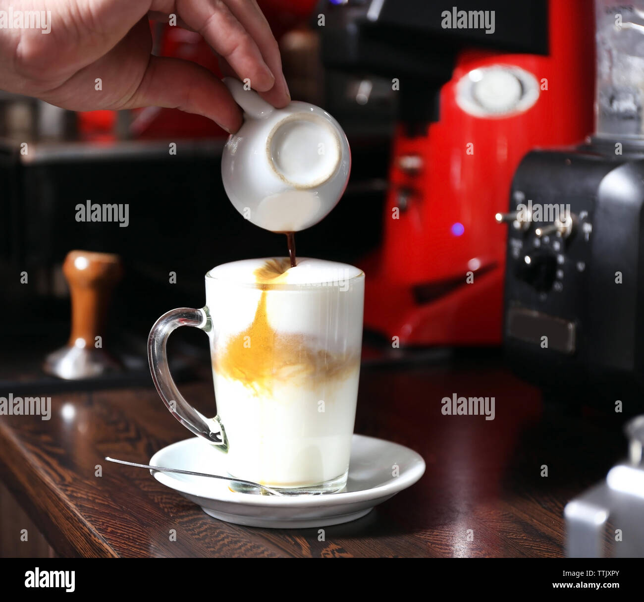 Barista making latte using coffee machine Stock Photo Alamy
