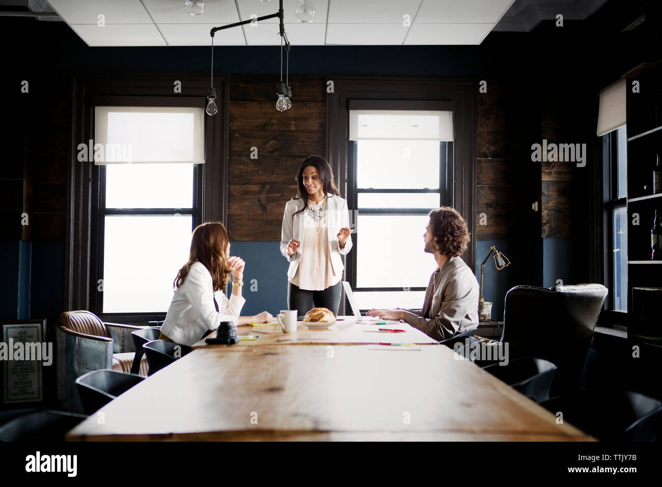 Colleagues looking at businesswoman explaining in office Stock Photo