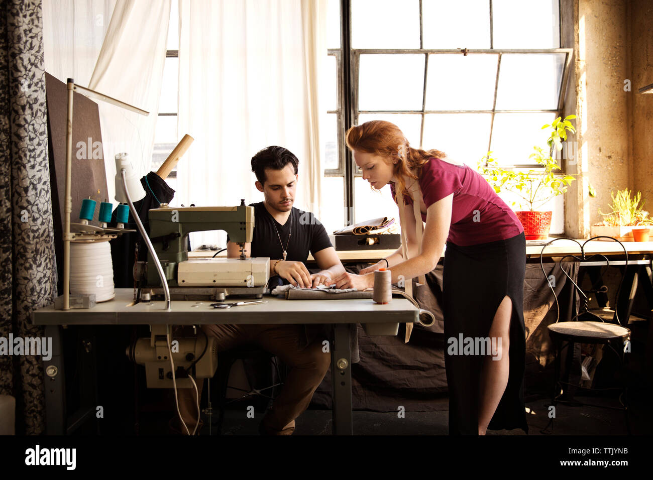 Fashion designers discussing over fabric at workshop Stock Photo