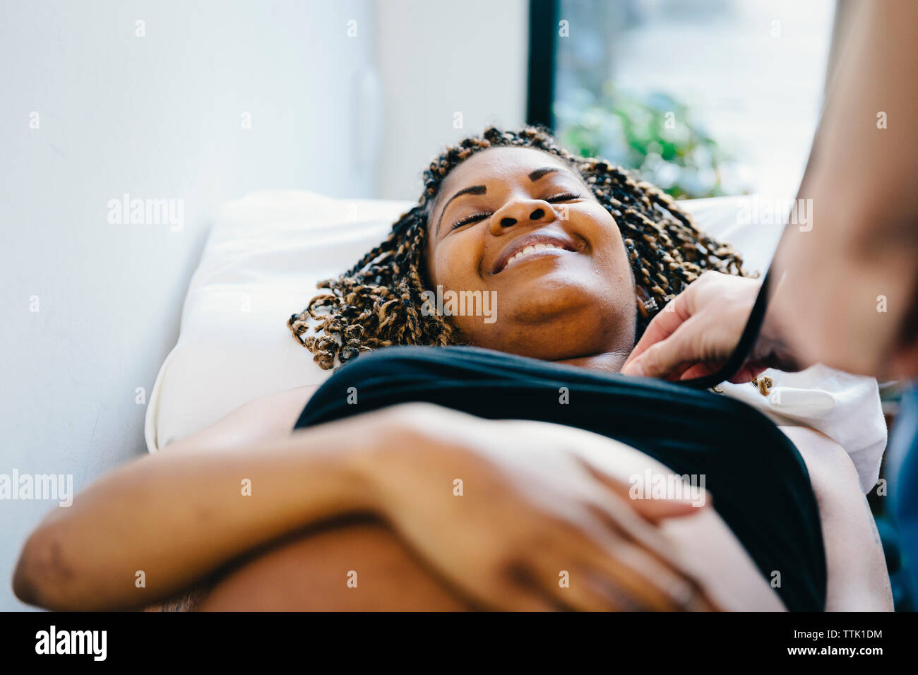 Cropped hand of doctor examining pregnant woman lying on bed in hospital Stock Photo