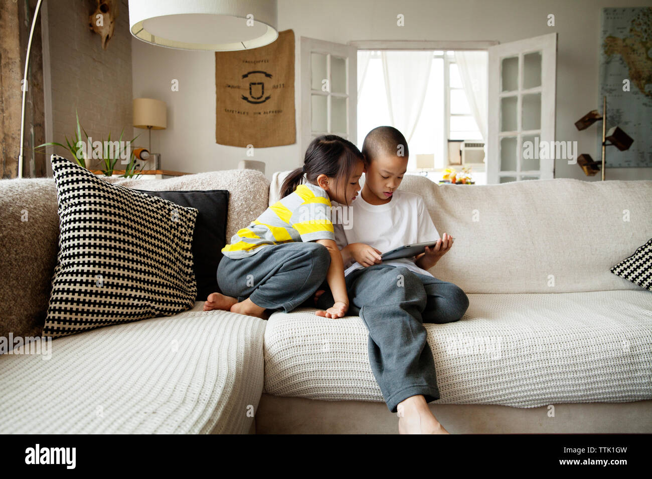 Brother sister sitting on sofa hi-res stock photography and images - Alamy