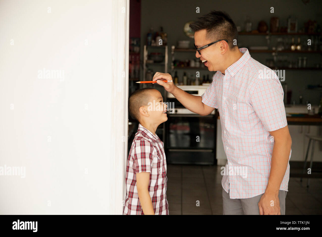 Father measuring son's height at home Stock Photo