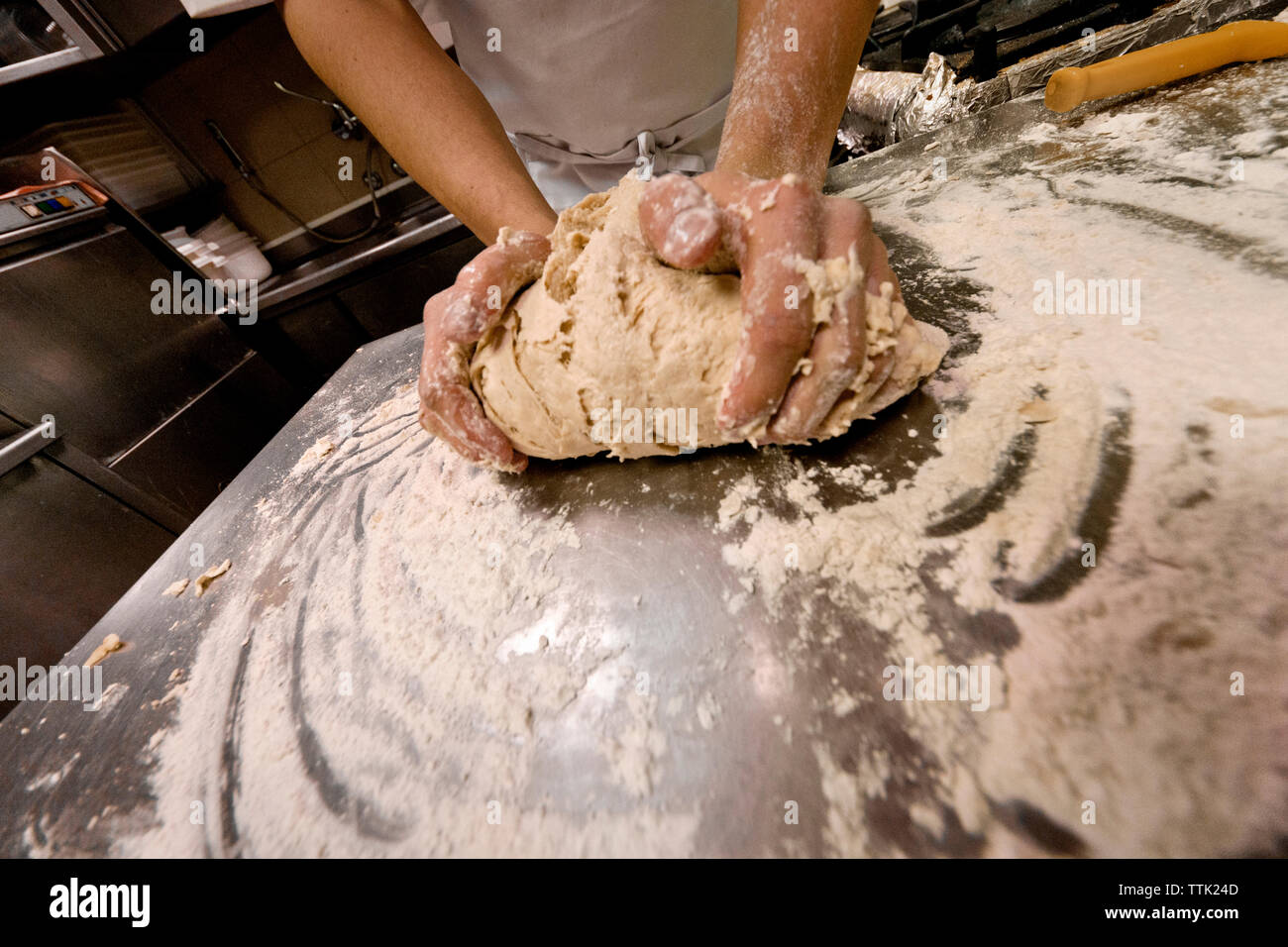 Midsection of chef kneading dough at commercial kitchen Stock Photo
