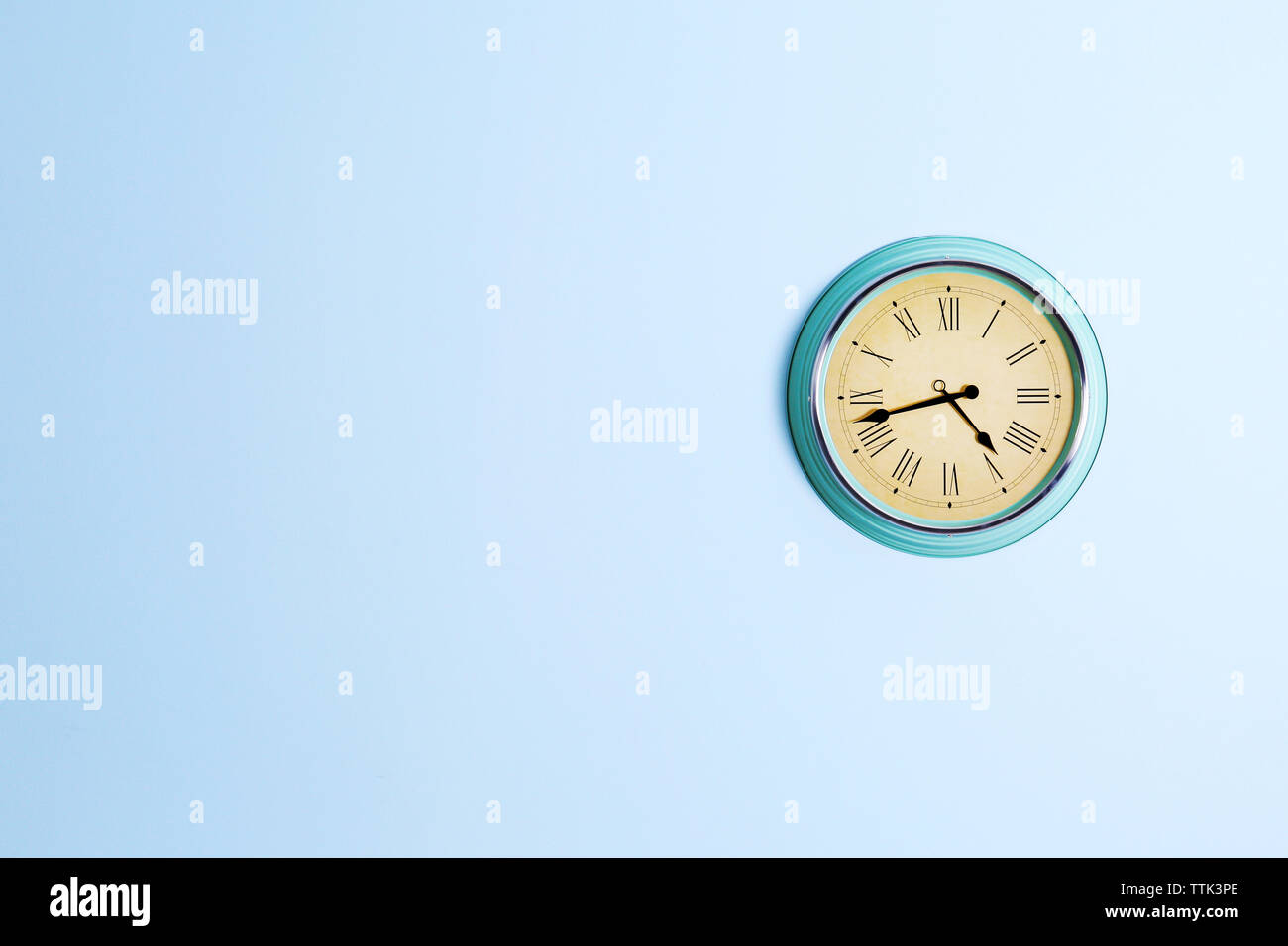 Vintage clock on blue wall background Stock Photo - Alamy