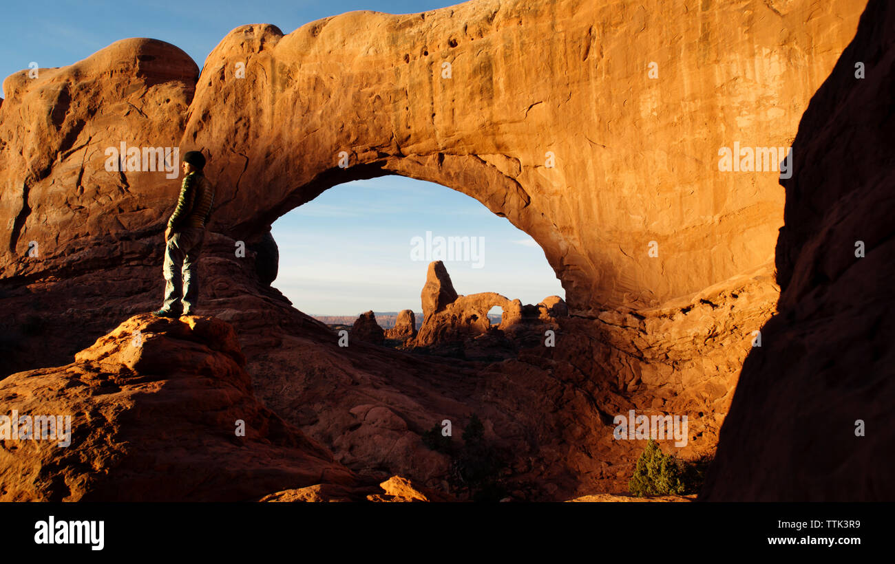 Man standing on rock formation at Arches National Park Stock Photo