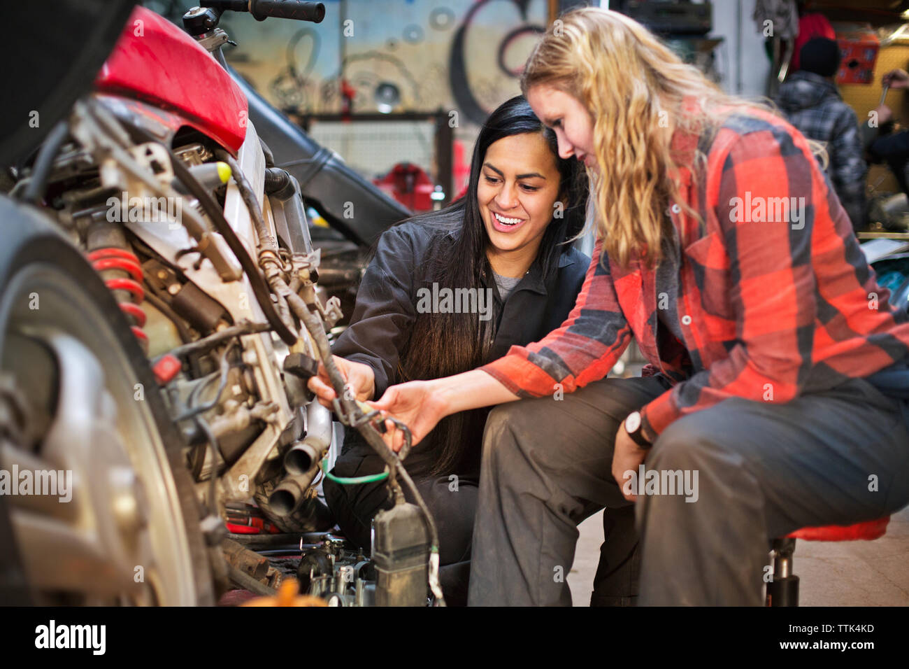 Happy female mechanics repairing bike in Stock Photo Alamy