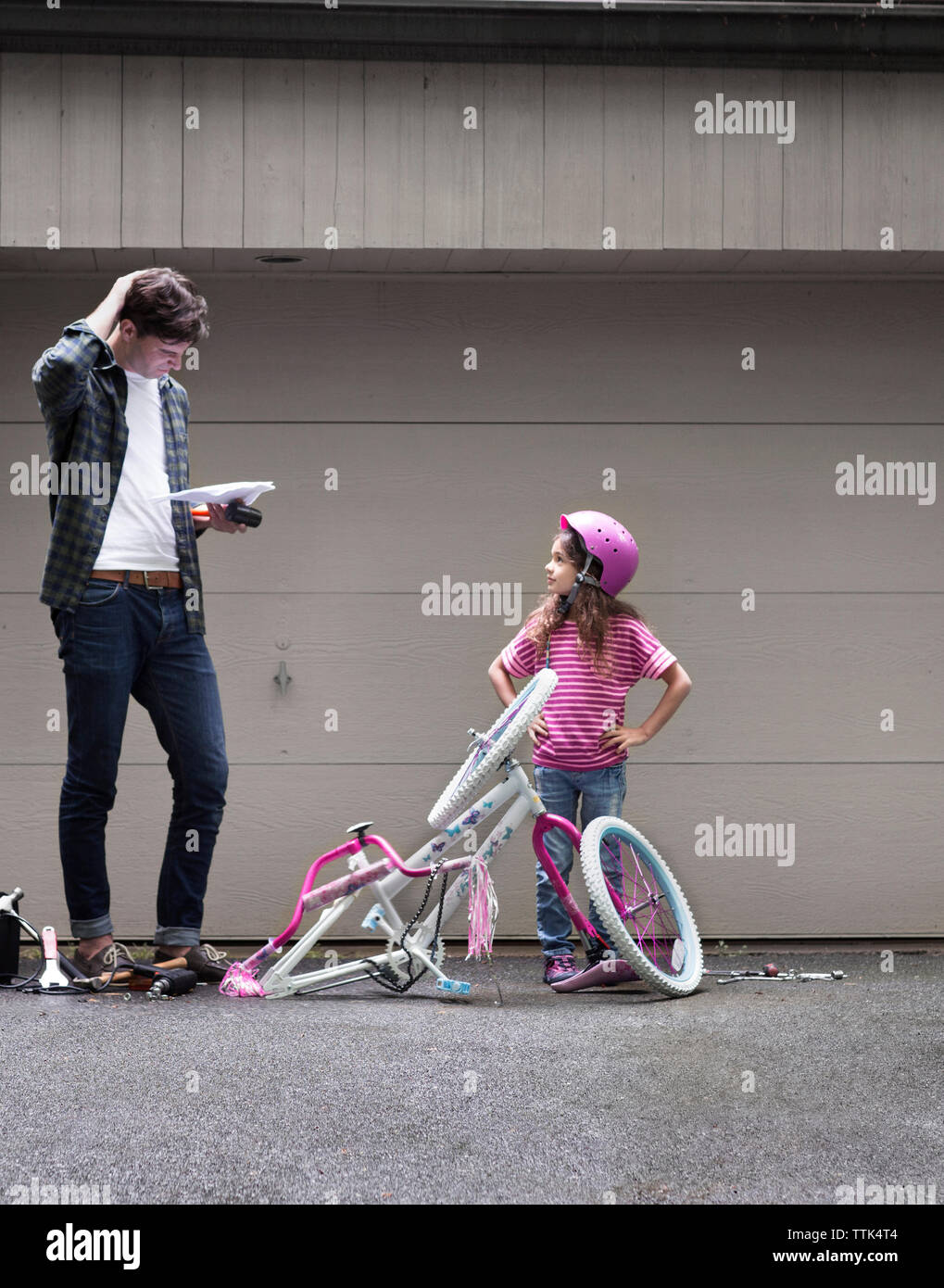 Father and daughter assembling bicycle Stock Photo