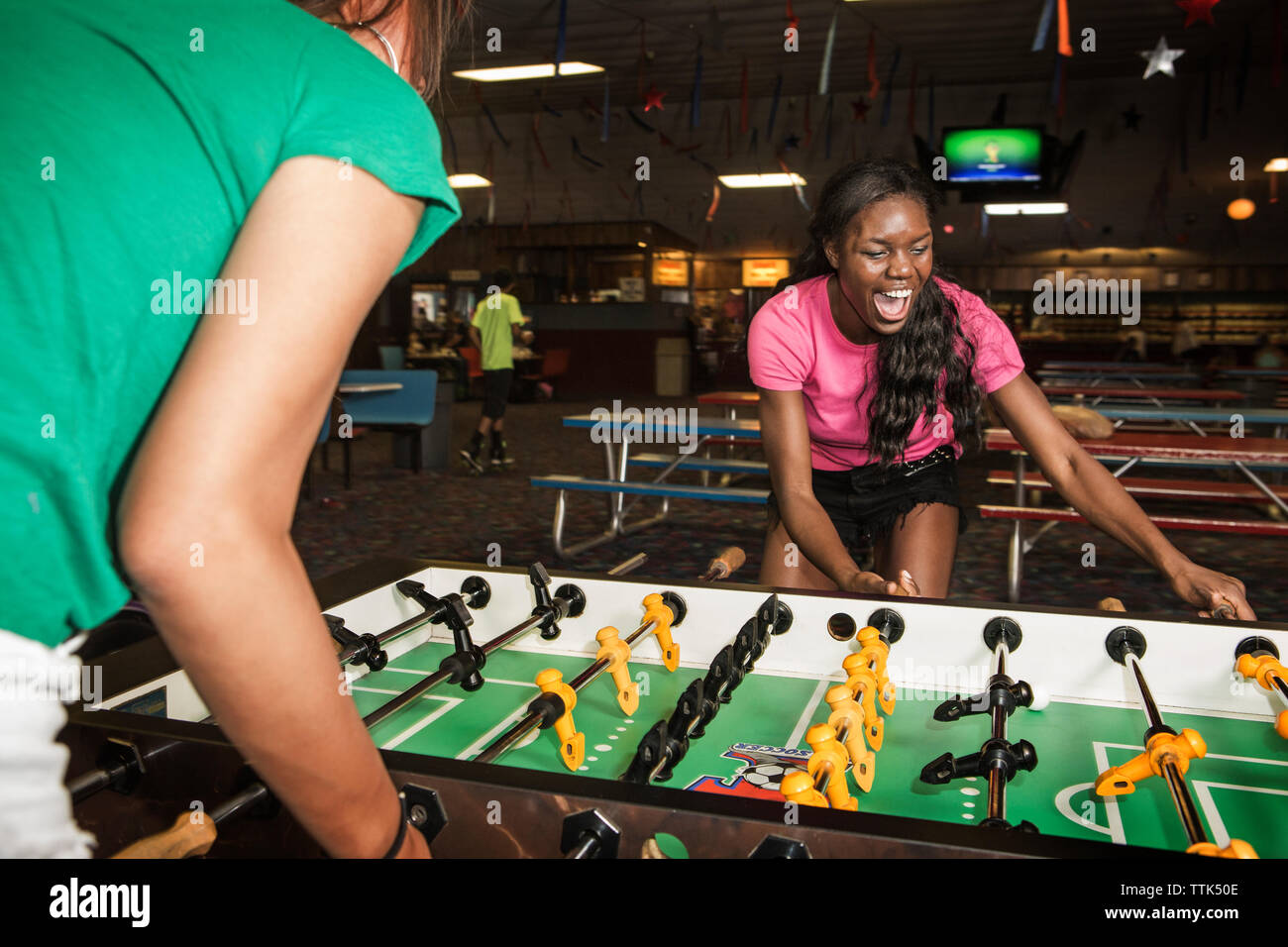 Friends enjoying foosball at club Stock Photo Alamy