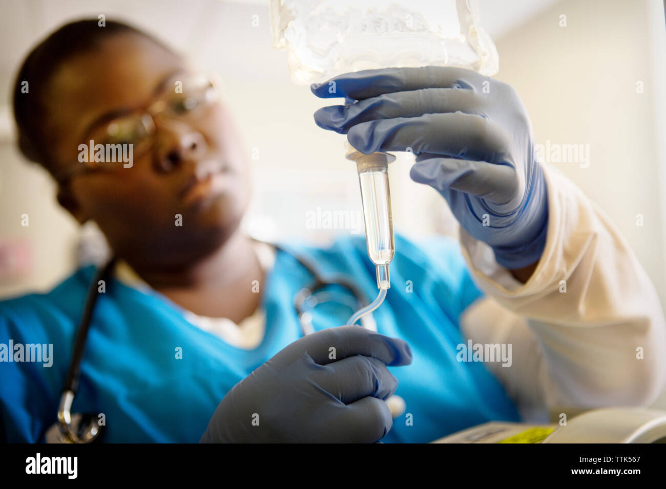 Nurse checking IV drip in hospital Stock Photo