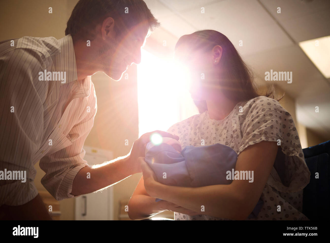 Low angle view of couple holding newborn child in hospital Stock Photo