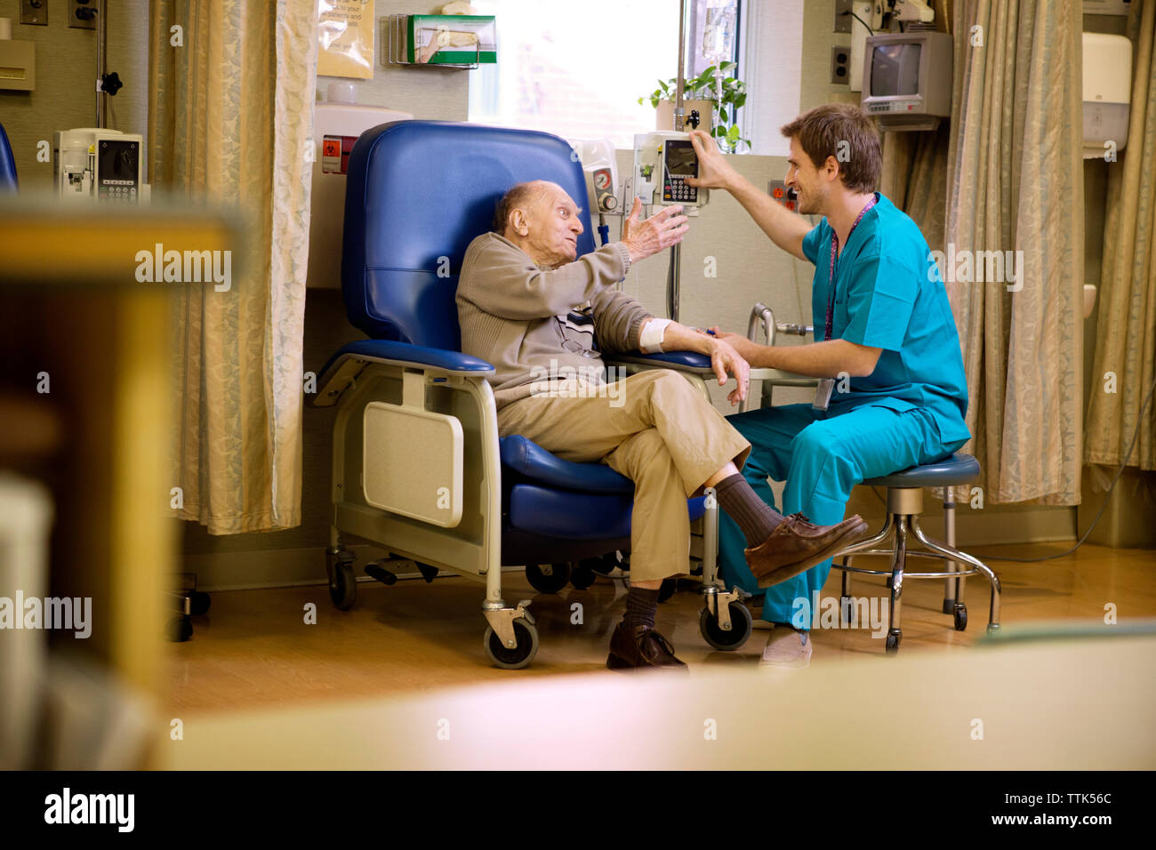 Male nurse checking senior patient in hospital Stock Photo