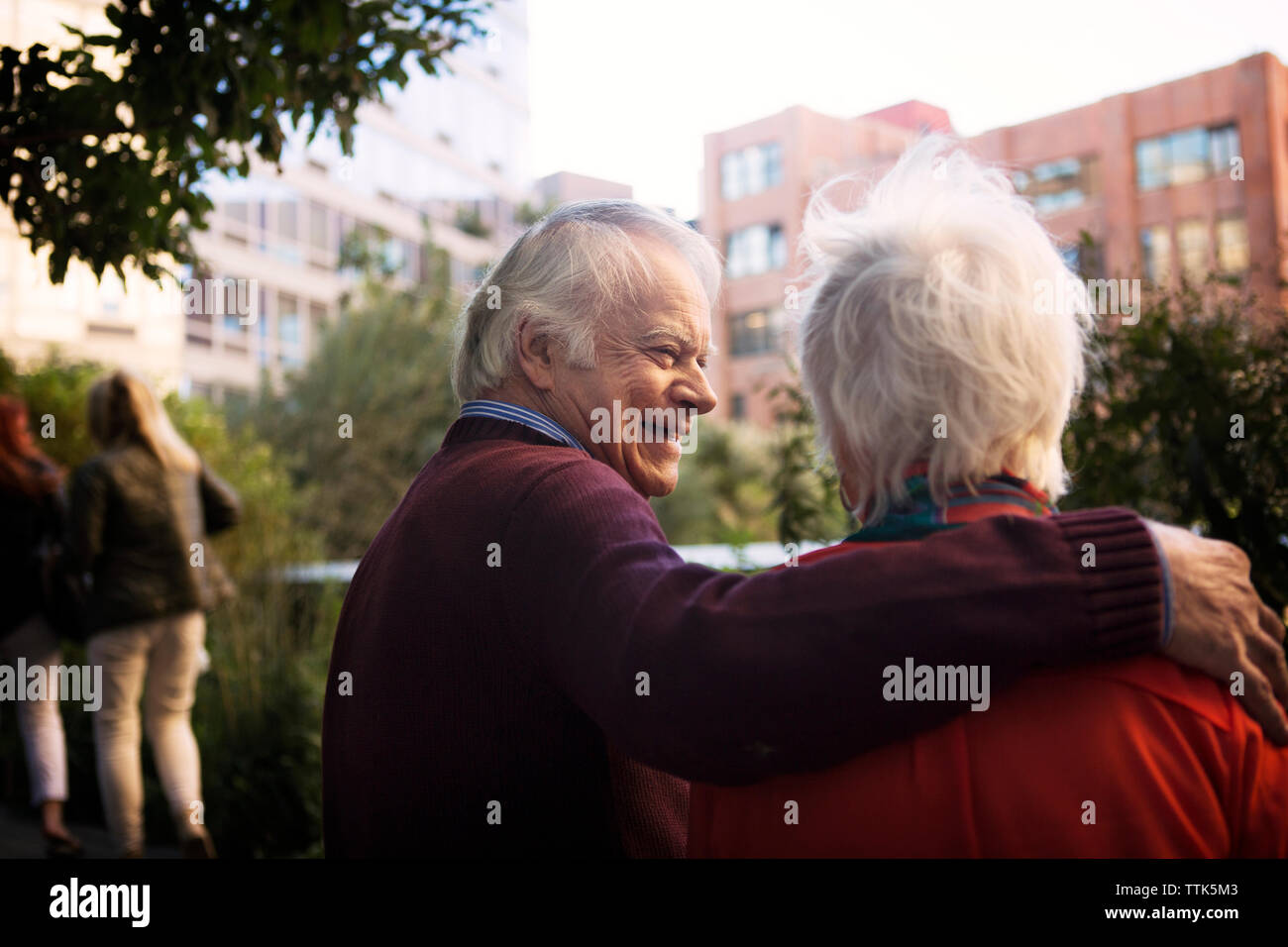 Happy senior man with arm around woman in city Stock Photo