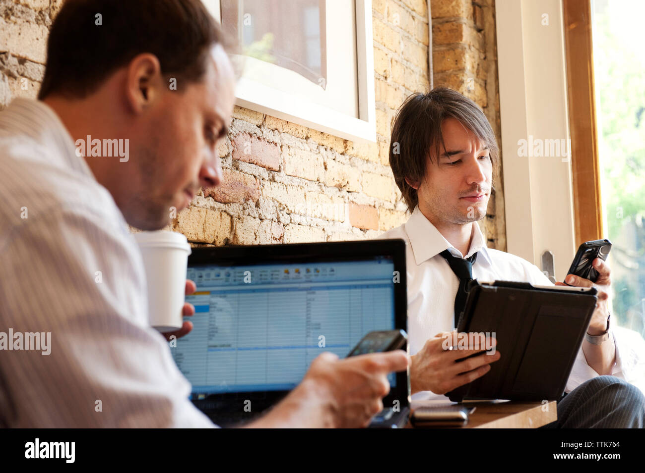 business people using mobile phone in cafe Stock Photo
