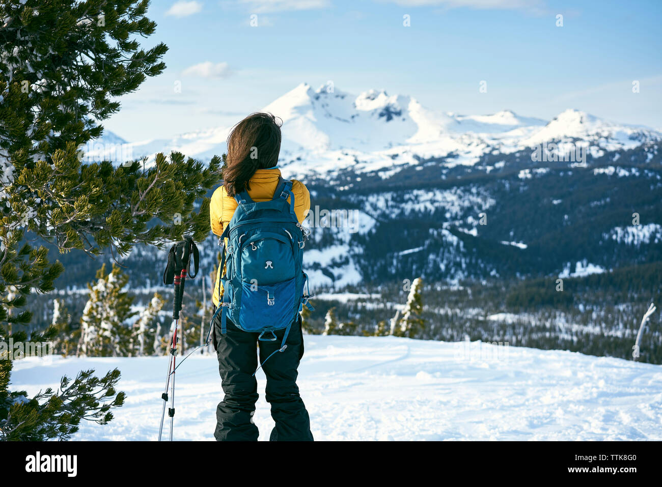 Rear view of woman standing on snow covered field Stock Photo - Alamy