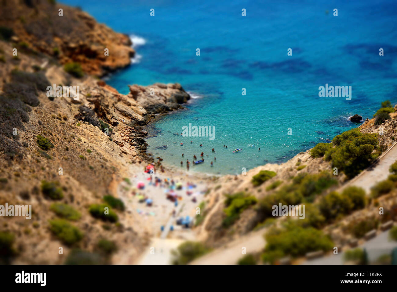 Tilt-shift image of tourists enjoying at beach Stock Photo