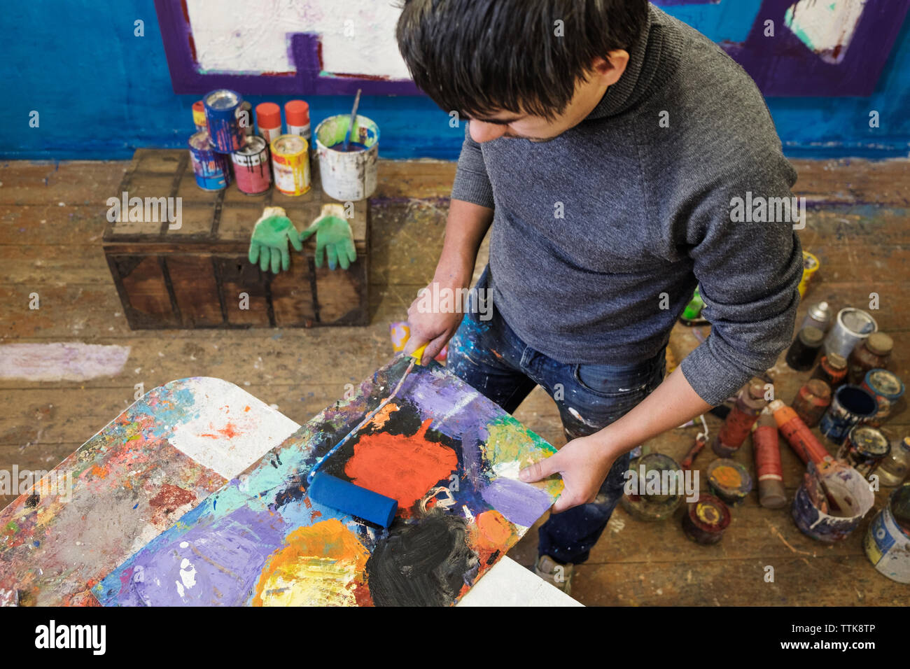 High angle view of male painter mixing paint on wood Stock Photo