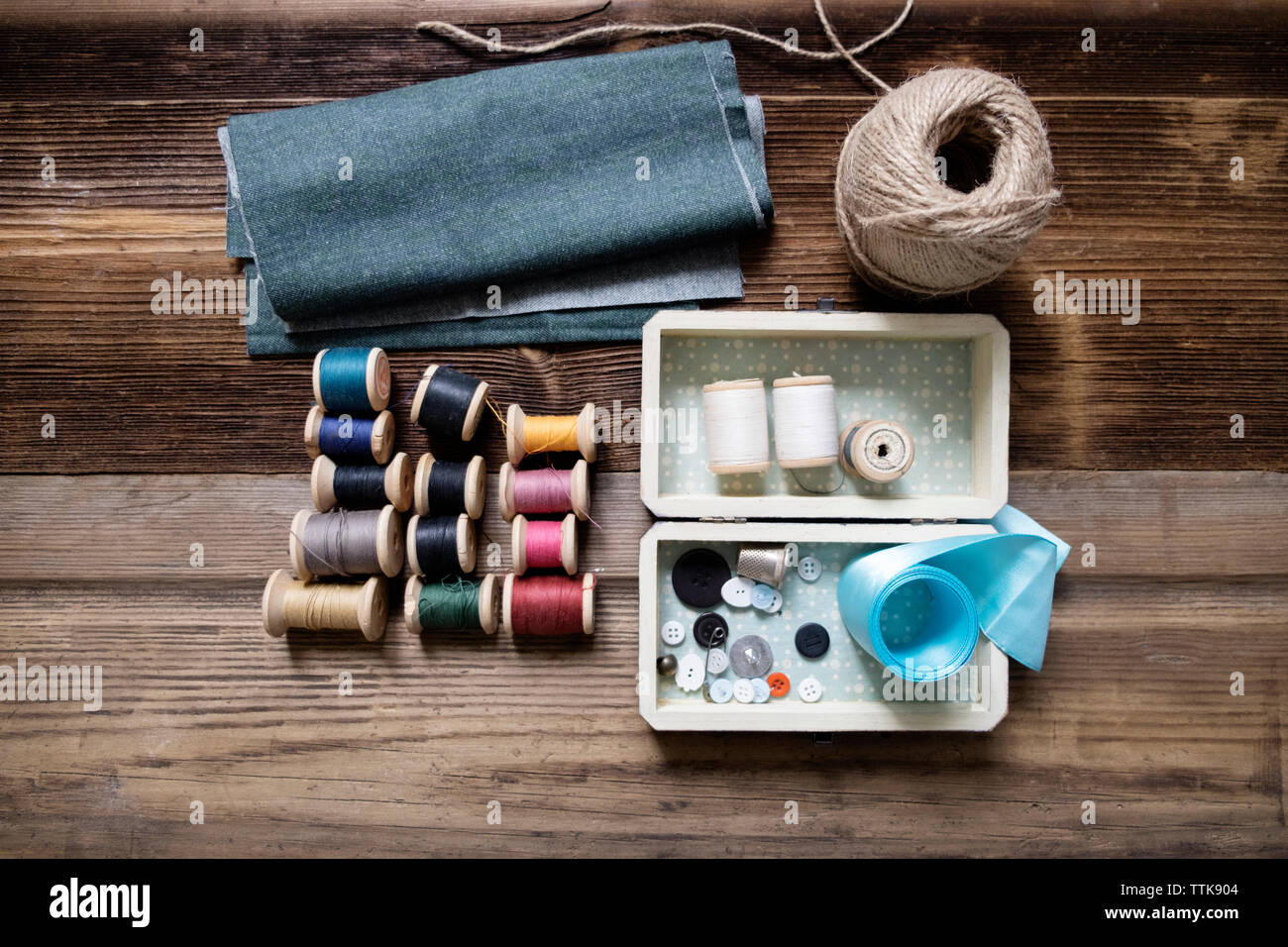 Overhead view of fabric with sewing equipment on table Stock Photo