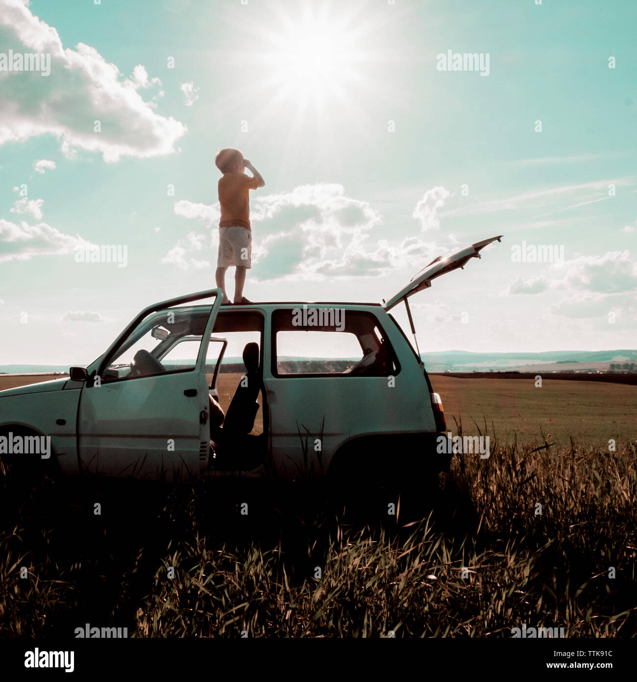 Boy standing on car roof hi-res stock photography and images - Alamy