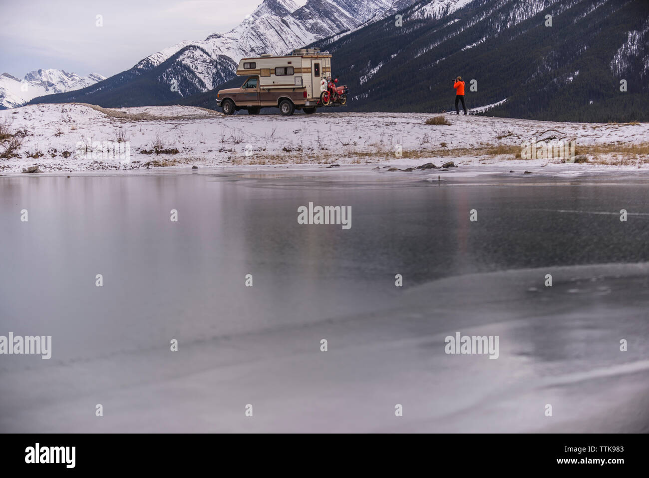 Man taking photo of Camper Truck with Touring Motorcycle in Canmore Stock Photo
