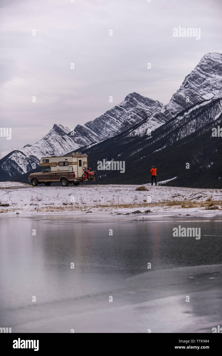 Man taking photo of Camper Truck with Touring Motorcycle in Canmore Stock Photo
