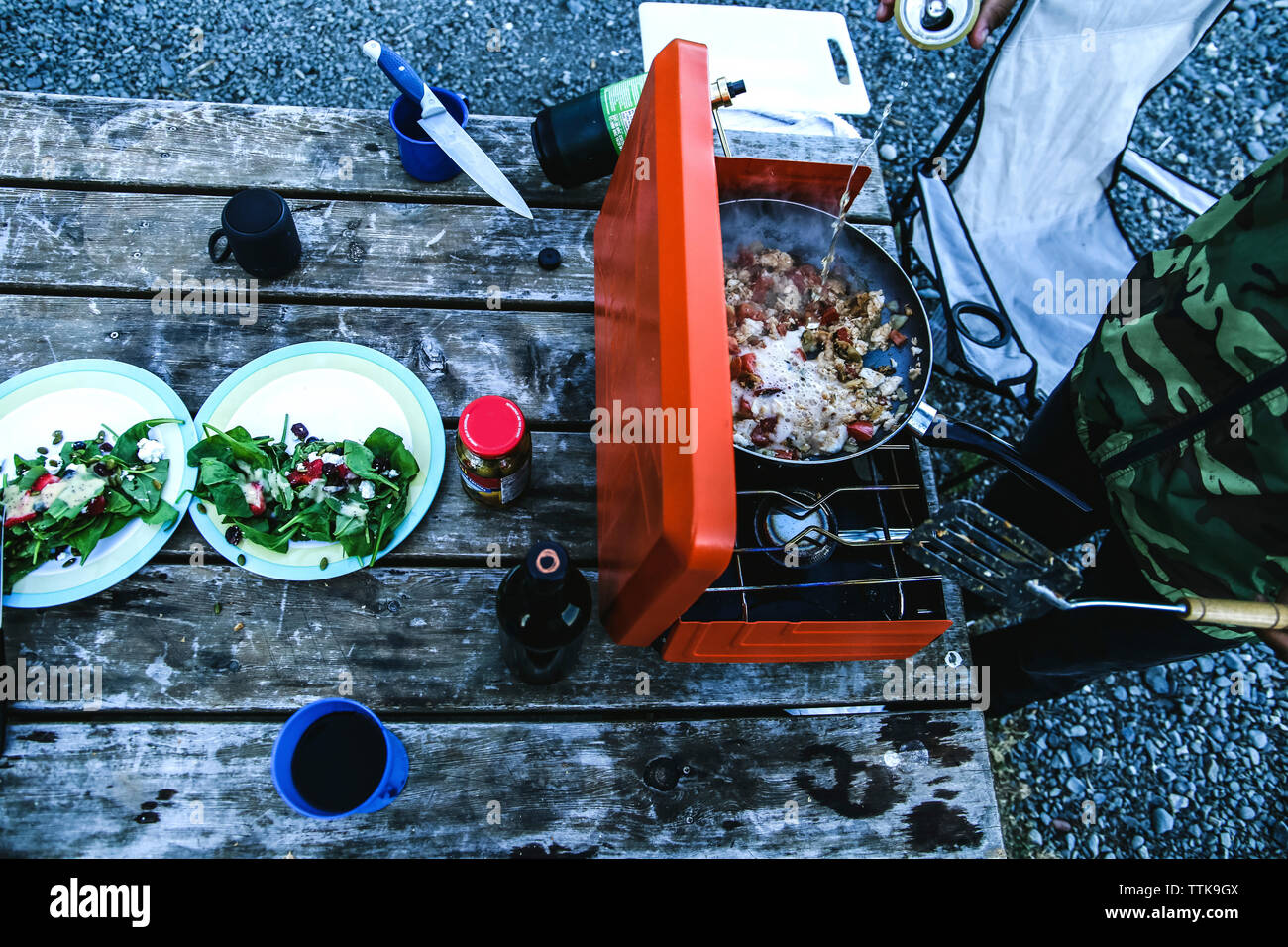 High angle view of man preparing food on barbeque at campsite Stock Photo