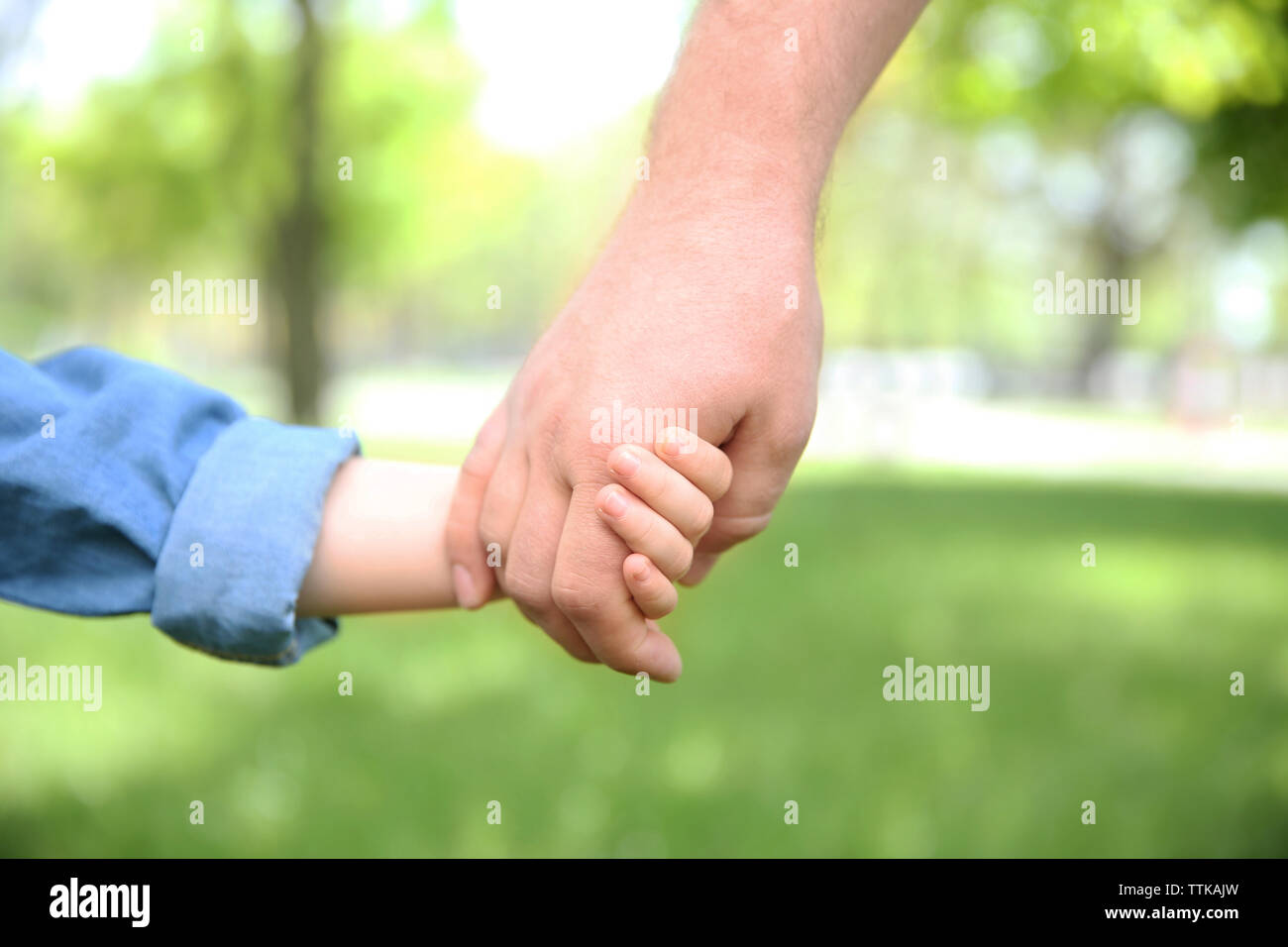 Adult and child hands on natural background Stock Photo - Alamy