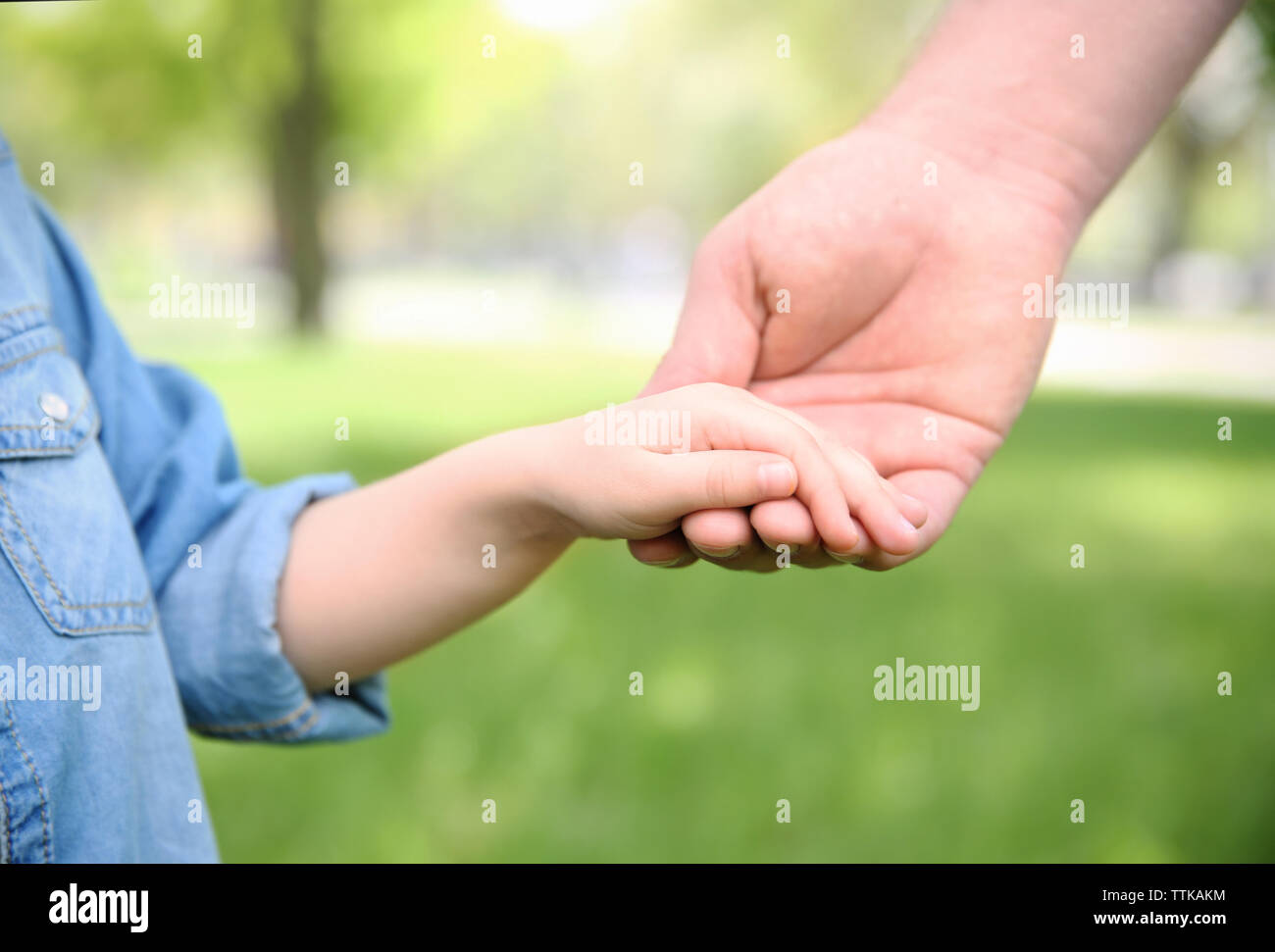 Adult and child hands on natural background Stock Photo - Alamy