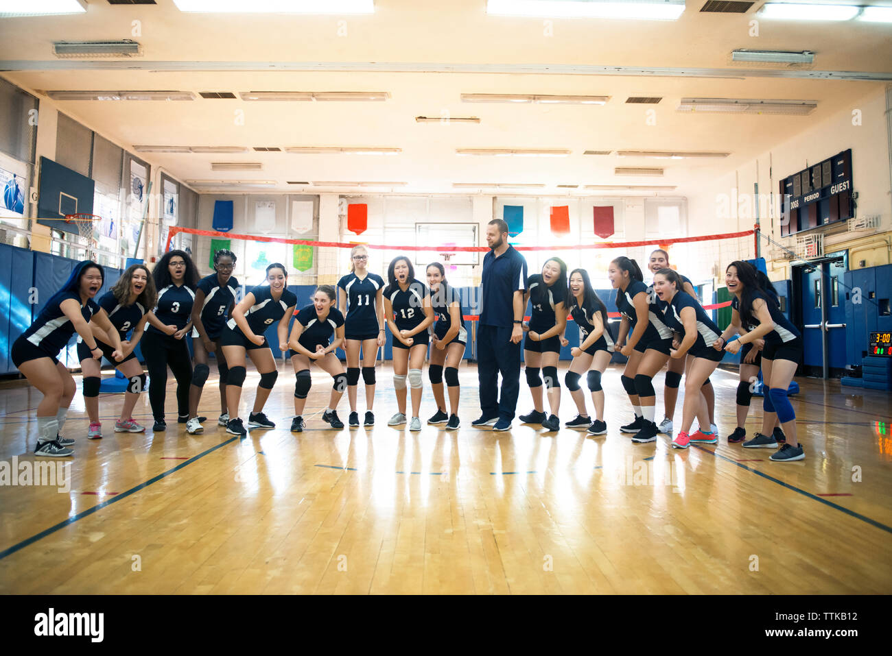 Instructor standing with female team in court Stock Photo - Alamy