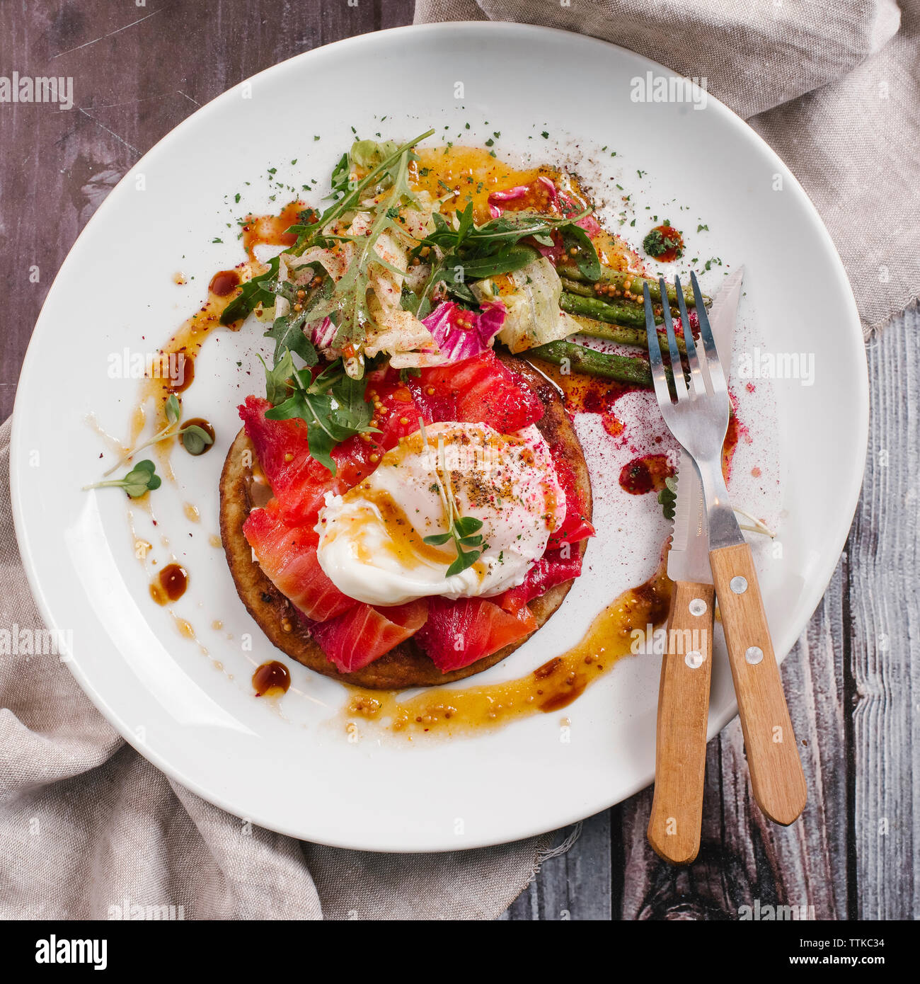 High angle view of savory crepes with salmon and poached egg in plate on table Stock Photo