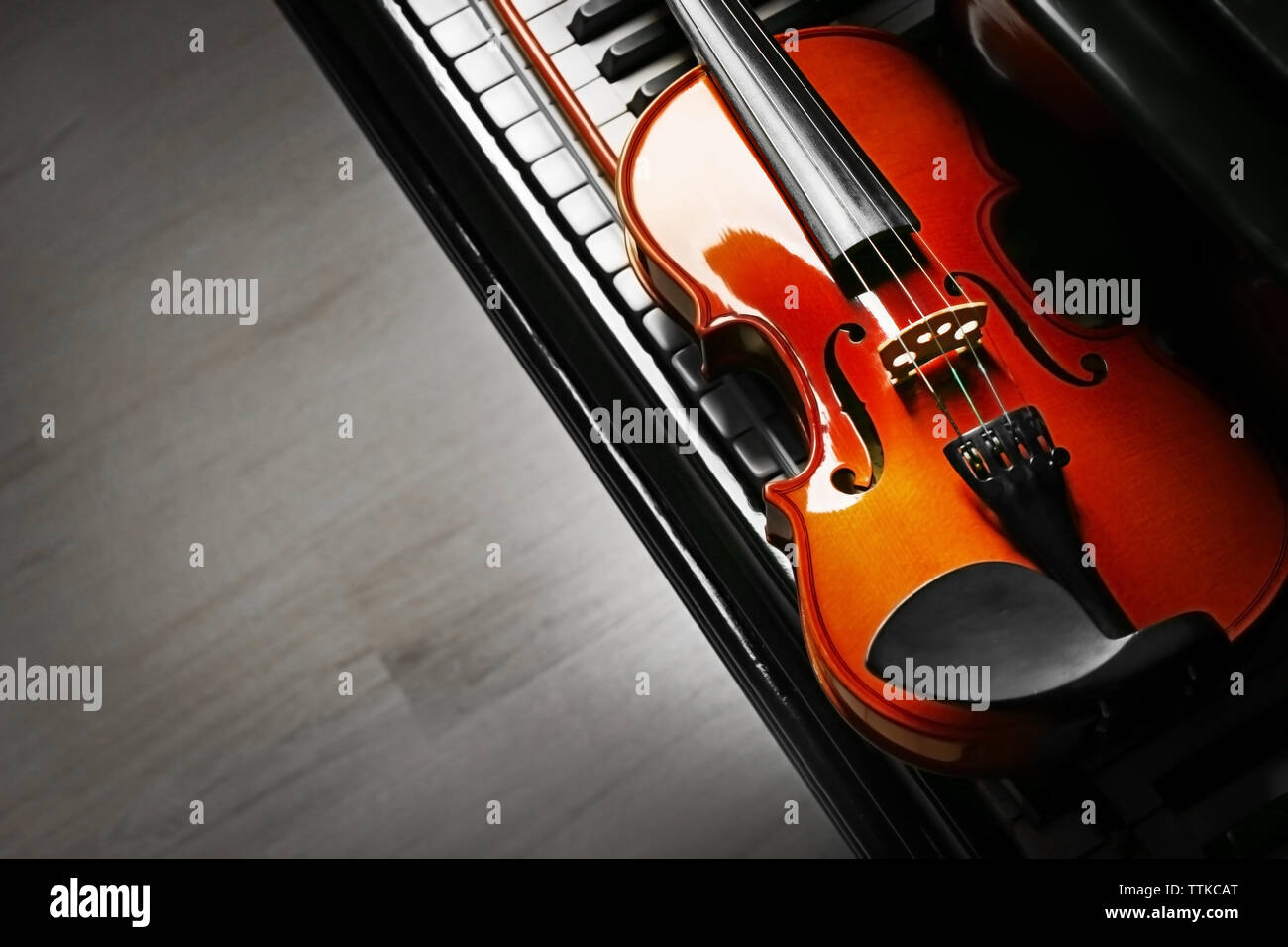 Violin lying on piano keys, close up Stock Photo