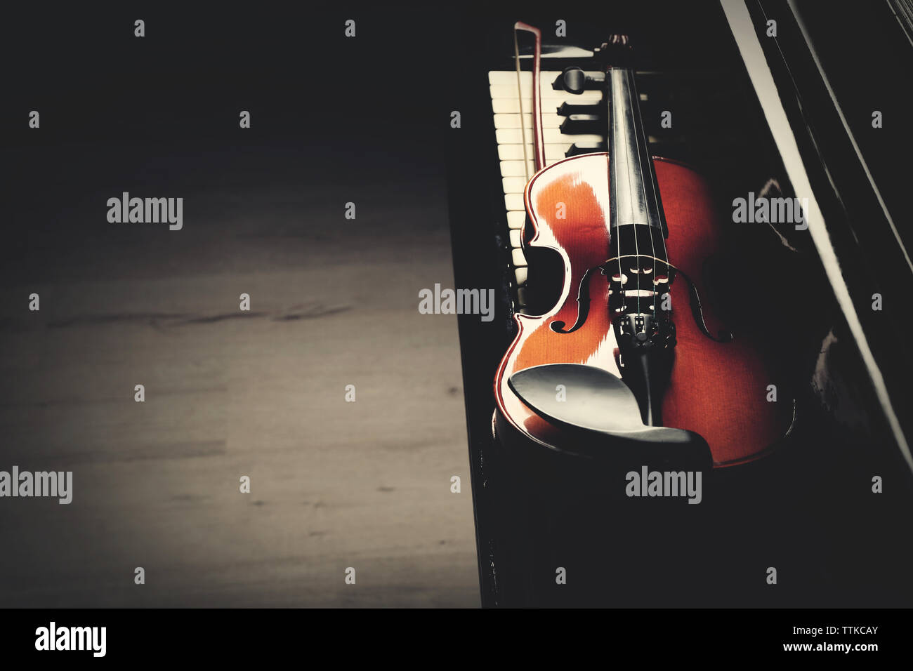 Violin lying on piano keys, close up Stock Photo