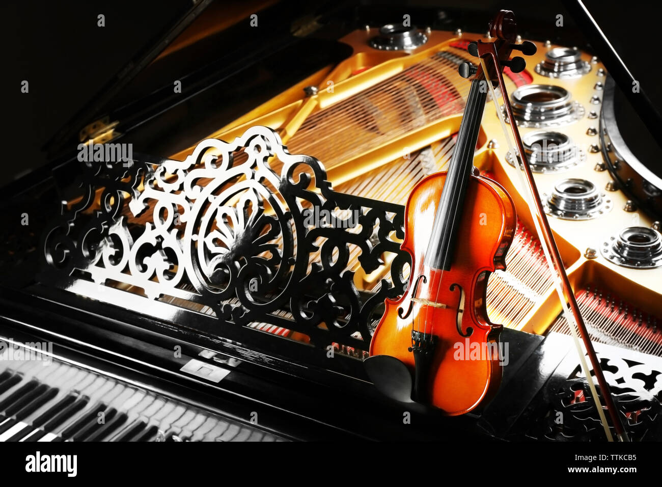 Violin lying on piano, close up Stock Photo
